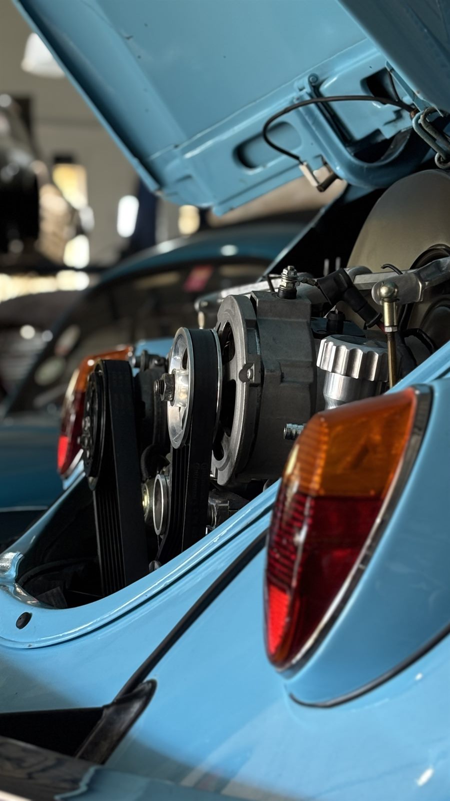 Detalhe do motor e da lanterna traseira de um Fusca azul-claro
