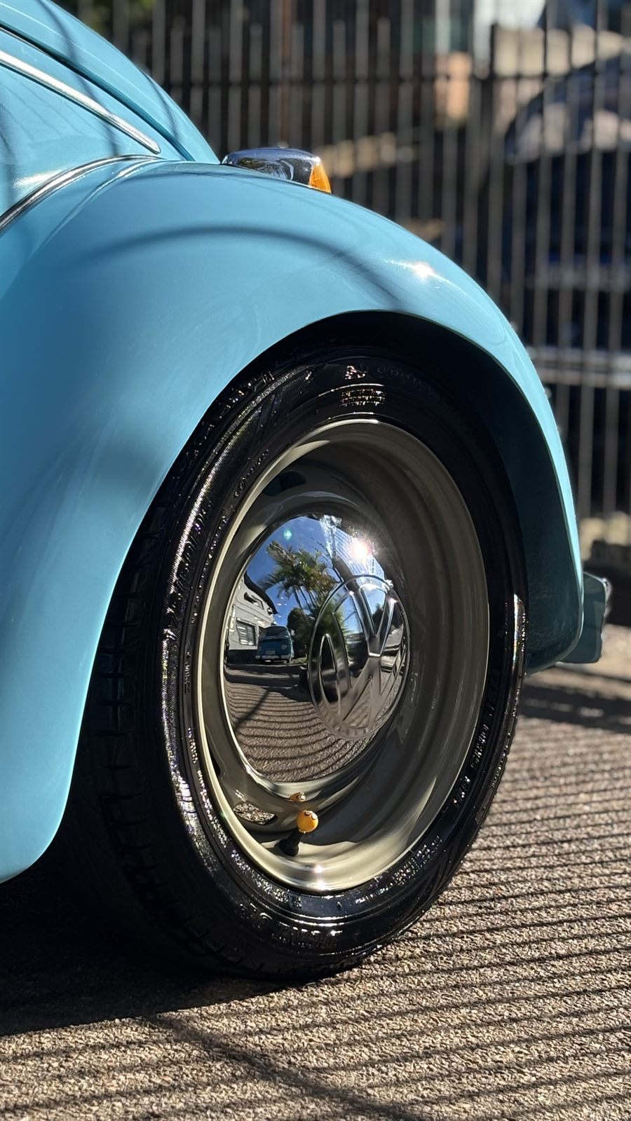 Detalhe da roda e do para-lama de um Fusca azul-claro